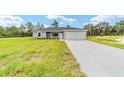 New construction home featuring a manicured front lawn and a spacious two-car garage at 315 Fisher Rd, Ocklawaha, FL 32179