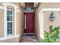 Inviting entryway showcasing a stylish front door and sidelight window at 3416 Gerber Daisy Ln, Oviedo, FL 32766