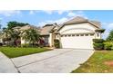 Elegant home with a manicured lawn, palm trees, and an attached two-car garage at 3617 Cherry Hill Dr, Orlando, FL 32822