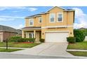 Inviting two-story home featuring a well-manicured lawn, lush landscaping, and an attached two-car garage at 3808 Enchantment Ln, St Cloud, FL 34772