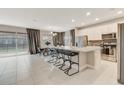 Open concept kitchen featuring a large center island with seating, stainless steel appliances, and tiled floors at 4418 Shiva Loop, Kissimmee, FL 34746
