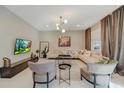 Bright, open living room featuring modern decor, stylish furniture, and contemporary lighting fixtures at 4418 Shiva Loop, Kissimmee, FL 34746
