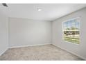 Bright bedroom with neutral tile floors, white walls, and a large window overlooking the front yard at 4423 Blackbird St, Kissimmee, FL 34746
