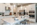 Modern kitchen with white cabinets, stainless steel appliances, large island and pendant lighting at 5235 Bowspirit Way, St Cloud, FL 34771