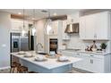 A modern kitchen shines with white cabinets, stainless appliances, a stylish island, and elegant pendant lighting at 5241 Quillback Ln, St Cloud, FL 34771