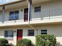 Close-up view of a two-story complex featuring blue railings and neatly trimmed bushes at 5505 Hernandes Dr # 118, Orlando, FL 32808