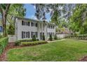 Beautiful two-story home with a manicured front lawn and mature trees providing shade at 613 Daniels Ave, Orlando, FL 32801