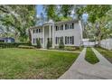 Charming two-story home with black shutters, manicured lawn, and gated driveway at 613 Daniels Ave, Orlando, FL 32801
