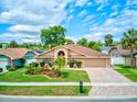 Inviting single-story house showcasing lush lawn and mature trees at 677 Cheoy Lee Cir, Winter Springs, FL 32708