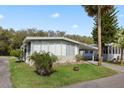Inviting single-story home featuring lush green lawn, mature trees, covered parking, and clean design at 8 Cocos Plumosa Dr # A, Eustis, FL 32726