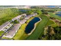 Aerial view of condo community with manicured lawns, pond, and golf course at 9423 Myrtle Creek Ln # 510, Orlando, FL 32832