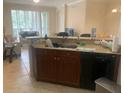 Efficient wet bar area with dark wood cabinets, granite countertops, stainless steel sink and black appliances at 11446 Jasper Kay Terrace # 202, Windermere, FL 34786