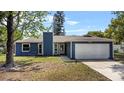 Charming single Gathering home with a blue exterior, complemented by a well-manicured front yard and attached garage at 1831 W Clinton Dr, St Cloud, FL 34769