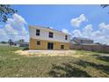The rear exterior of the home showcasing a patio, spacious yard, and slider door entry at 2004 Prescott Blvd, Deltona, FL 32738
