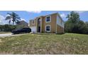 Two-story home with a well-manicured lawn, featuring an attached garage and trimmed garden beds at 2004 Prescott Blvd, Deltona, FL 32738
