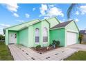 Charming, mint-green single-Gathering home with a well-maintained lawn and two arched windows at 202 Aylesbury Ln, Davenport, FL 33837