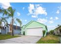 Charming, mint-green single-Gathering home with a well-maintained lawn and a two-car garage at 202 Aylesbury Ln, Davenport, FL 33837