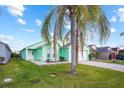 Charming, mint-green single-Gathering home with a well-maintained lawn and two palm trees at 202 Aylesbury Ln, Davenport, FL 33837