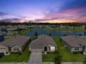 Aerial view of a home overlooking a serene lake with community park in a residential neighborhood at 3348 Perennial Ln, Kissimmee, FL 34746
