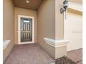 Front entrance featuring a modern black door and brick-paved entryway next to a spacious garage at 8828 Bengal Ct, Kissimmee, FL 34747