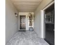 Covered front entry features tiled floor, gray walls, and a stylish black front door at 1052 Dees Dr, Oviedo, FL 32765