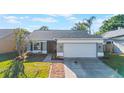 Inviting single-story home with gray exterior, well-maintained landscaping, and a spacious driveway at 1052 Dees Dr, Oviedo, FL 32765