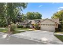 Lovely house with a two-car garage, concrete driveway, and inviting curb appeal, showcasing a suburban home at 1017 American Beauty St, Orlando, FL 32818
