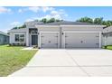 Attractive gray stucco home with a pristine lawn and a two-car garage at 113 St Thomas Dr, Mulberry, FL 33860