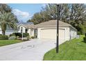 Inviting single-story home with a spacious driveway and well-manicured front lawn at 1309 Carolina Ct, The Villages, FL 32162