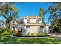 Charming two-story home showcasing a well-maintained lawn and circular garden beds at 1374 Century Oak Dr, Ocoee, FL 34761