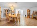Dining room with tiled floor, chandelier, wood furniture and bright light from windows and door at 1430 Clarks Summit Ct, Orlando, FL 32828