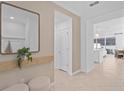 Stylish entryway featuring a decorative mirror, neutral tones, and an open layout at 16164 Palm Frond Ave, Clermont, FL 34714