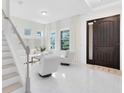 Bright foyer featuring a modern staircase, tile flooring, and a front door at 1675 Amsel Falls Park Ter, Winter Garden, FL 34787