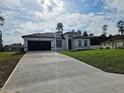Charming single-story home with a dark two car garage and a long concrete driveway at 17167 Sw 40 Ter, Ocala, FL 34473