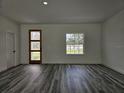Open living room featuring wood-look flooring, a modern wood door, and a view of the outdoors at 17167 Sw 40 Ter, Ocala, FL 34473