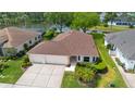 Aerial view of a home showcasing its landscaping and proximity to the adjacent lake at 1842 Turnbull Lakes Dr, New Smyrna Beach, FL 32168