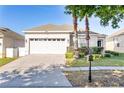 Charming single-story home with a two-car garage, well-manicured lawn, and a brick-paved driveway at 217 Herring St, Davenport, FL 33897
