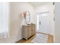 Bright foyer featuring a decorative mirror, a wooden console table, and a patterned rug on the hardwood floors at 217 Herring St, Davenport, FL 33897