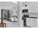 Modern kitchen with stainless steel appliances, ample white cabinetry, and stylish black countertops at 220 Palmer Park Ln, Davenport, FL 33897