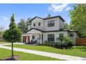 Inviting two-story home with a modern wood garage door, manicured lawn, and lush landscaping at 2306 Hargill Dr, Orlando, FL 32806