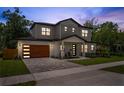 Charming two-story home featuring a wood garage door, large windows, and inviting front porch at 2306 Hargill Dr, Orlando, FL 32806