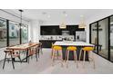 Bright, modern kitchen with sleek black cabinets, stainless steel appliances, island, and adjacent dining area at 235 Villa Domani Cir, Davenport, FL 33896