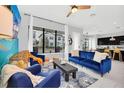 Contemporary living room featuring stylish blue furniture, large windows, and an open-concept design at 235 Villa Domani Cir, Davenport, FL 33896