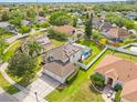 Aerial view of a home with a pool, a fenced backyard, and solar panels on the roof at 239 Longhirst Loop, Ocoee, FL 34761