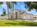 Beautiful exterior view of home, showcasing lush lawn and mature trees at 239 Longhirst Loop, Ocoee, FL 34761