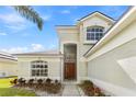 Inviting entrance with a striking front door, detailed landscaping, and well-maintained walkway at 239 Longhirst Loop, Ocoee, FL 34761
