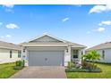 Home featuring a brick paver driveway leading up to a two-car garage and a neatly landscaped garden at 2457 Cliff Way, St Cloud, FL 34771