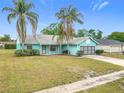 Quaint single-story home featuring a gray roof, turquoise siding, and driveway, set against a clear blue sky at 2558 Academy Ave, Deltona, FL 32738