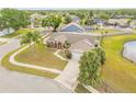 An aerial view of a home with palm trees, a lush lawn, and a pond in a well-kept neighborhood at 2844 Eagle Lake Dr, Orlando, FL 32837