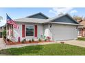 Charming single-story home with a two-car garage, red shutters, and well-manicured front lawn at 3192 Running Deer Path, Kissimmee, FL 34746